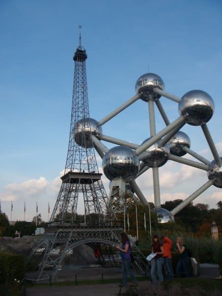 sculpture of an atom next to miniature model of Eiffel Tower