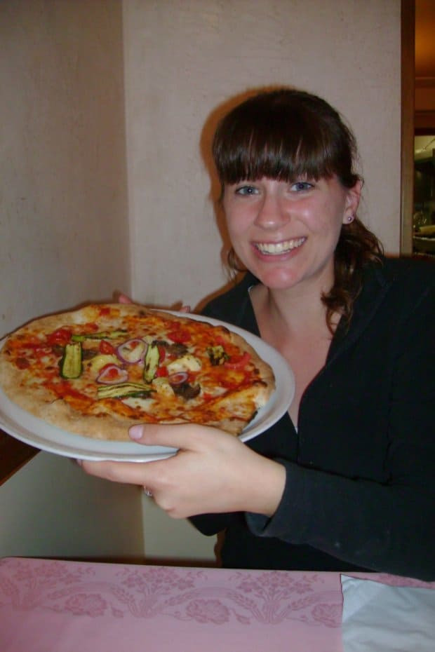 woman holding a homemade pizza
