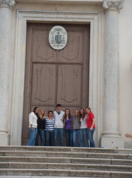 group of students standing outside a large cathedral