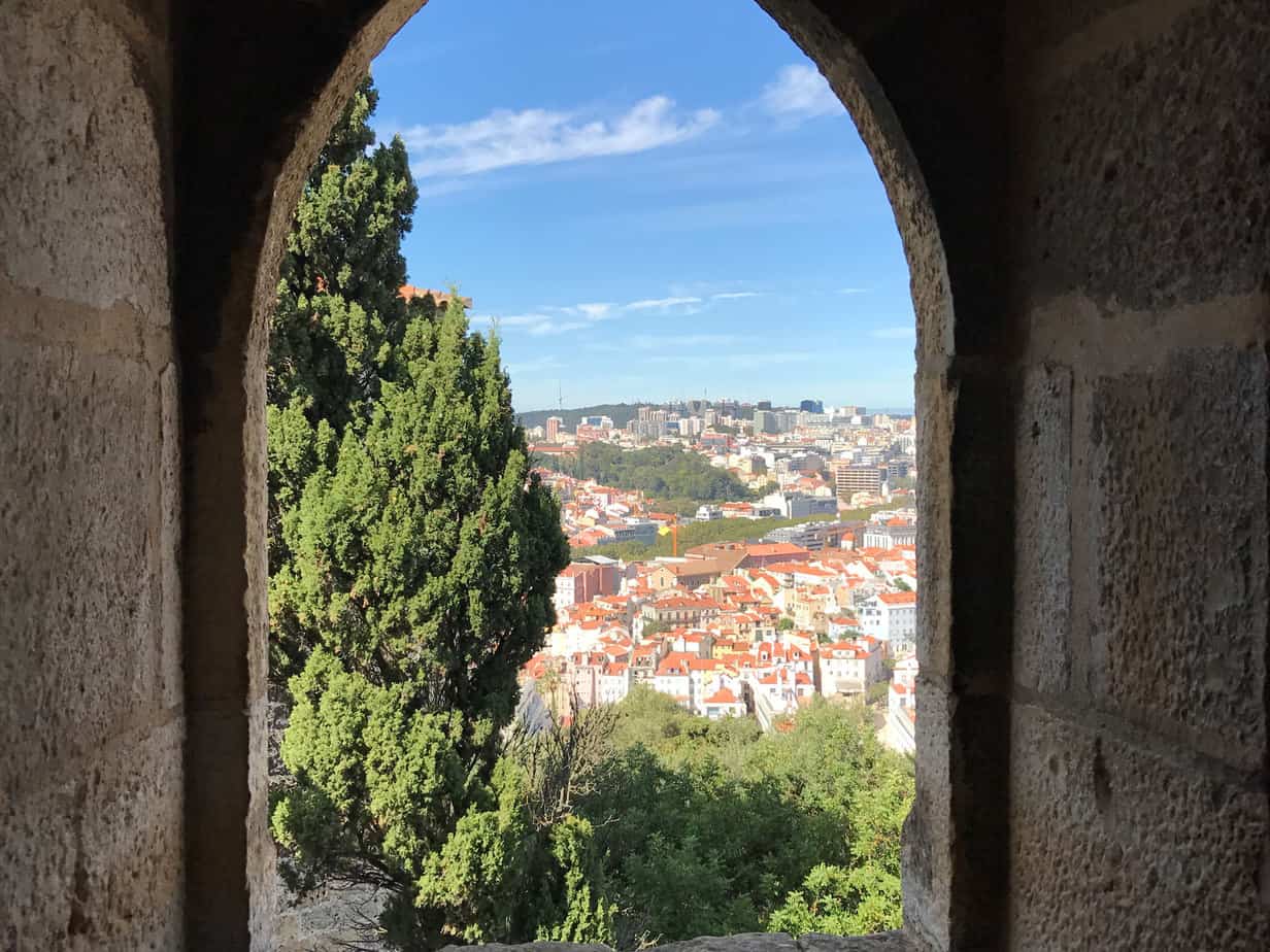 view of city out the window of a stone medieval castle